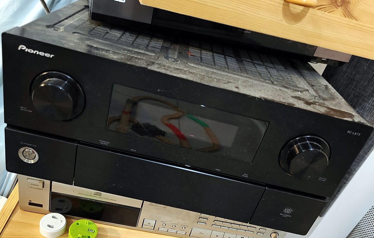 Front of the Pioneer SC-LX73 AV receiver: input selector and master volume knobs either side of the display, a fine layer of dust on top