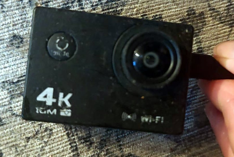 The front of the AT-03 action cam: a lens, a round button, and the text 4K and Wi-Fi printed on the black case